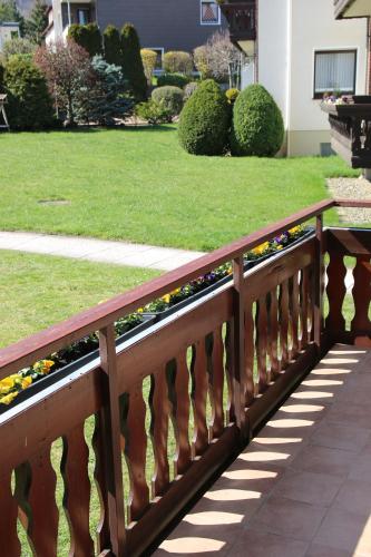 a wooden fence with flowers on a lawn at Viktoria‘s Ferienwohnung in Bad Harzburg