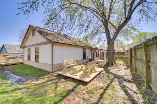 a backyard with a white house and a fence at Barling Vacation Rental Fenced-In Yard with Hot Tub in Barling