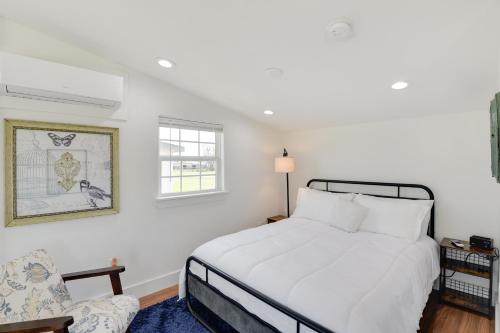a white bedroom with a bed and a chair at Pet-Friendly Bowie Studio with Deck! in Bowie