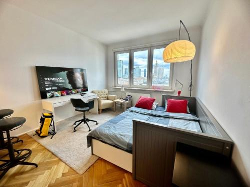 a bedroom with a bed and a desk and a tv at Super BEAUTY metro WiFi 65’TV Netflix HBO AppleTV+ in Warsaw