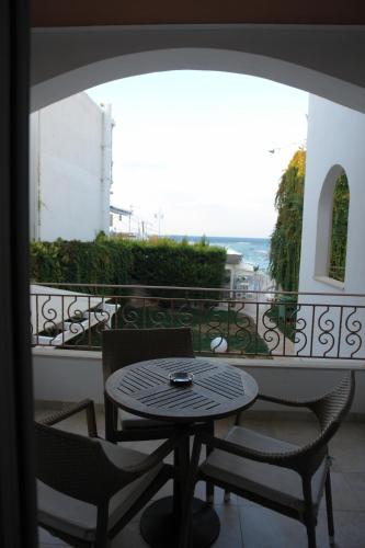 a table and chairs on a balcony with a view at Oasis Beach Hotel in Skala