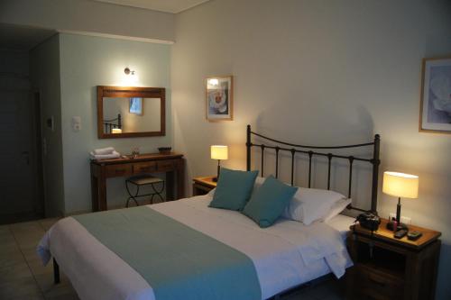 a bedroom with a large bed and a mirror at Oasis Beach Hotel in Skala