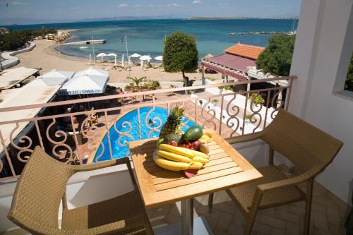 a table with a bunch of fruit on a balcony at Oasis Beach Hotel in Skala