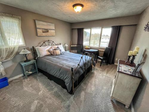 a bedroom with a bed and a desk and window at Sunny Shuswap B&B in Chase