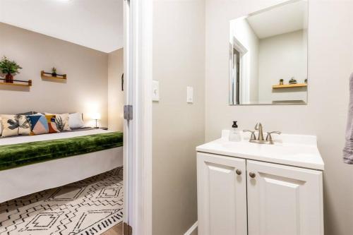 uma casa de banho com um lavatório e uma cama num quarto em Modern, Rustic Farmhouse Apartment near Downtown em Mount Clemens
