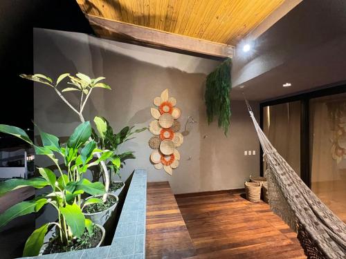 einen Flur mit Pflanzen an der Wand und eine Treppe in der Unterkunft Milagres Hospedagens - Cobertura Rota 206 - Capela & Praia in São Miguel dos Milagres