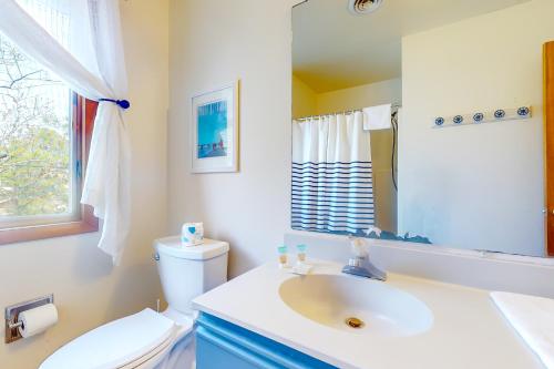 ein Badezimmer mit einem Waschbecken, einem WC und einem Spiegel in der Unterkunft South Bethany - 99 Mays Way in Bethany Beach