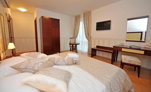 a bedroom with a large white bed and a desk at Guesthouse Villa Vice in Split