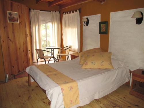 Schlafzimmer mit einem Bett, einem Tisch und Stühlen in der Unterkunft Cabañas Los Arreboles in Potrerillos