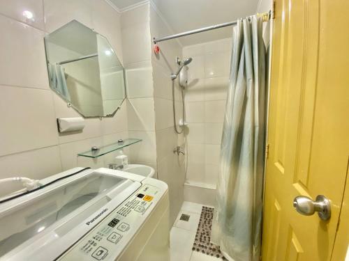 a bathroom with a tub and a sink and a mirror at 2BR within the heart of the City with WIFI and Netflix in Davao City