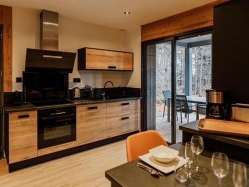 une cuisine avec une table et une salle à manger dans l'établissement Lodge avec bain à remous privatif, proche du golf et piscine réservée - Confort et activités garanties - FR-1-582-373, au Chambon-sur-Lignon