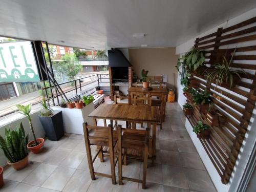 a restaurant with wooden tables and chairs and a balcony at Como en casa Hostel in Posadas