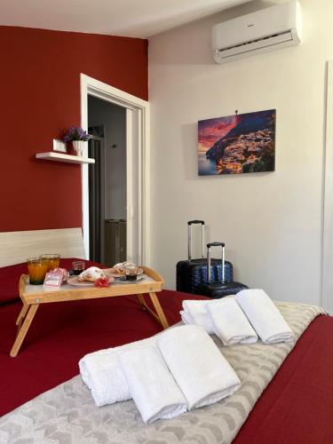 a room with a bed and a table with towels at Il Tempio Di Giove Suite Pompei in Pompei