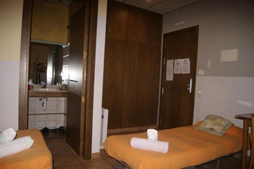 巴加的住宿－HOTEL FAMILIAR BAGA，一间设有两张床铺和毛巾的房间