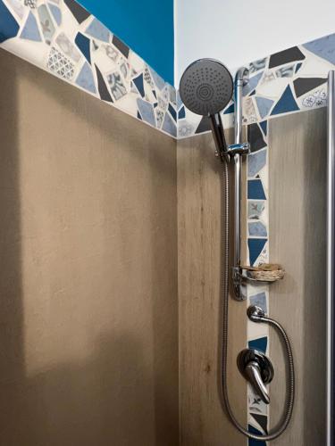 a shower in a bathroom with blue and white tiles at Il Tempio Di Giove Suite Pompei in Pompei