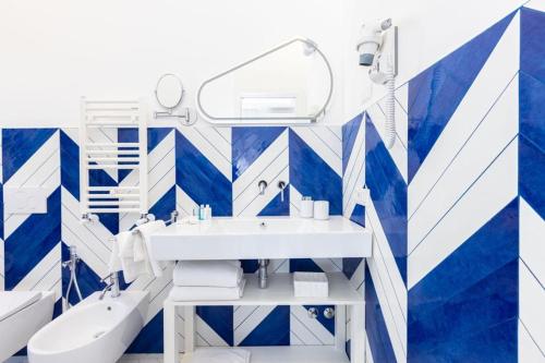 a bathroom with blue and white walls and a sink at Pupatella Luxury Suite in Sorrento