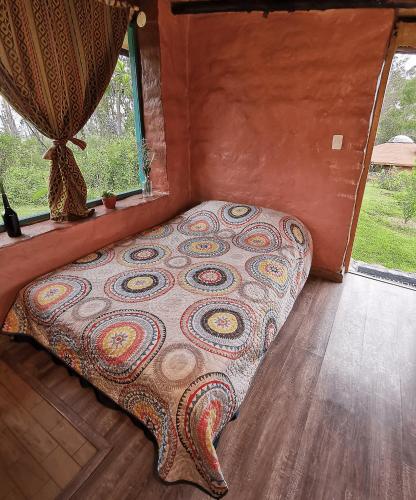 伊瓦拉的住宿－Uchilla Wasi - Casa Suaya La Esperanza，一个小房间的一个床位,设有窗户