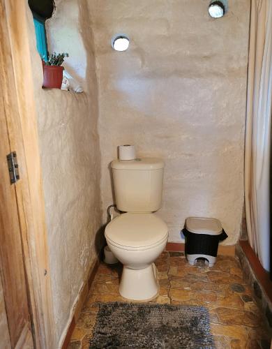 a bathroom with a toilet in a small room at Uchilla Wasi - Casa Suaya La Esperanza in Ibarra