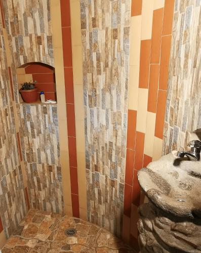 a bathroom with a sink and a mosaic wall at Uchilla Wasi - Casa Suaya La Esperanza in Ibarra