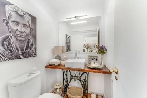 uma casa de banho com um WC, um lavatório e um espelho. em Casa da Praia em Estoril