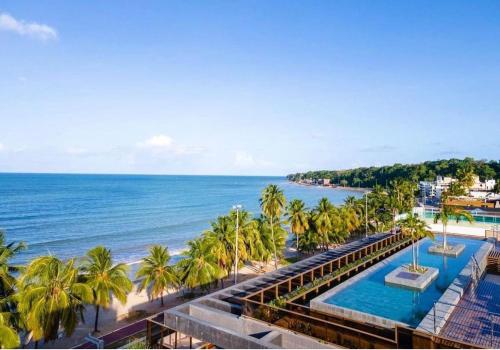 uma vista para uma praia com palmeiras e para o oceano em Unity - Cabo Branco by Jess em João Pessoa