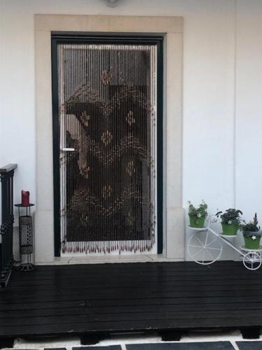 a front door of a house with a gold screen at Courtyard House - Sun, Barbecue, Beach in Sesimbra