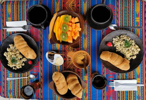 伊瓦拉的住宿－Uchilla Wasi - Casa Suaya La Esperanza，餐桌,盘子上放着食物和蔬菜碗