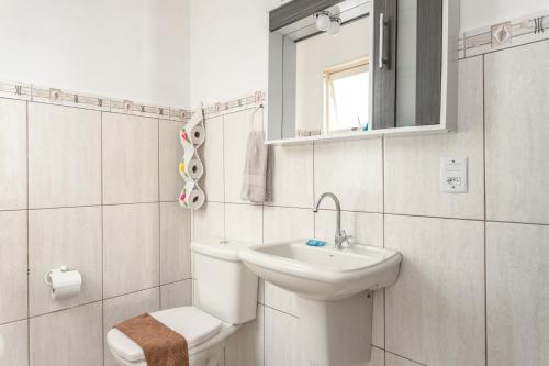 a bathroom with a toilet and a sink and a mirror at Linda casa a 150m da praia e prox ao Beto Carrero in Penha