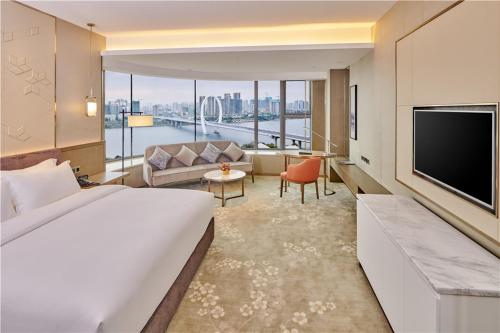 Habitación de hotel con cama grande y sala de estar. en SHENZHENAIR SKY PARK LIUZHOU, en Liuzhou