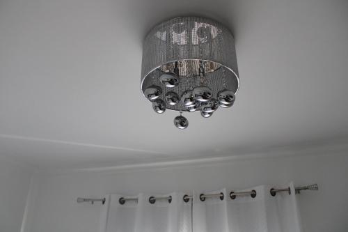 a chandelier hanging from a ceiling in a bathroom at Alexia Room in Funchal
