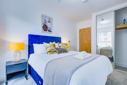 a bedroom with a blue and white bed and a window at Luxe Apartment by Excel in London