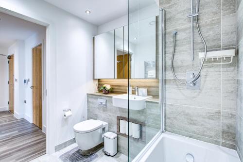 a bathroom with a shower and a toilet and a sink at Luxe Apartment by Excel in London