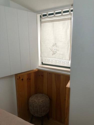 a window in a room with a chair in front of it at Courtyard House - Sun, Barbecue, Beach in Sesimbra
