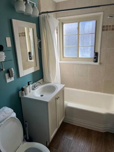 a bathroom with a sink and a tub and a toilet at Cozy 3BR Condo near OSU Perfect for Students, Workers & Staycations in Columbus