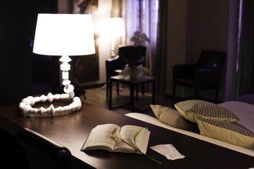 a table with an open book and a lamp and a lamp at Hotel Las Terrazas & Suite in Albolote