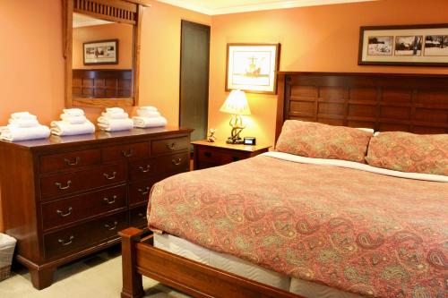 a bedroom with a bed and a dresser with a mirror at Condo 7 Slopeside With Private Sauna and Hot Tub in Killington