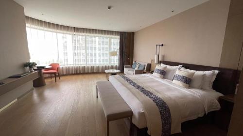 Habitación de hotel con cama grande y ventana grande. en SHENZHENAIR SKY PARK LIUZHOU, en Liuzhou