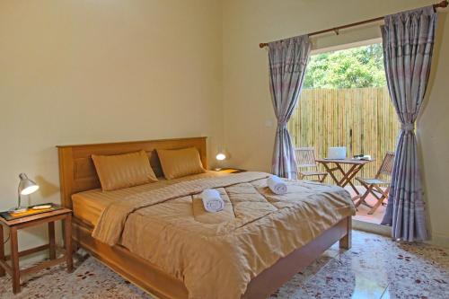 ein Schlafzimmer mit einem Bett mit zwei Handtüchern darauf in der Unterkunft Arcadia Downtown Backpackers in Kampot