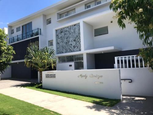 a white house with a sign in front of it at Unit 3 - Manly Boutique Apartments in Brisbane