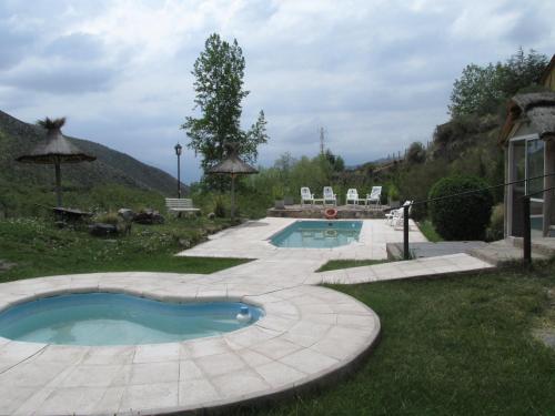 ein Schwimmbad in der Mitte eines Gartens in der Unterkunft Cabañas Los Arreboles in Potrerillos