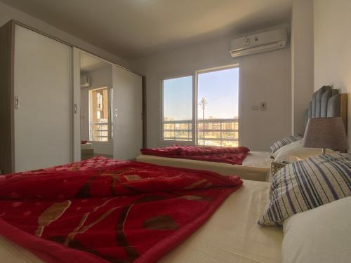 a bedroom with two beds and a large window at Luxury Inn: 3BR Amazing View in Madinaty B6 in Madinaty