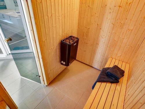 a small bathroom with a bench and a trash can at Luxury Pool Villa in Grena - By Traum Ferienwohnungen in Grenå