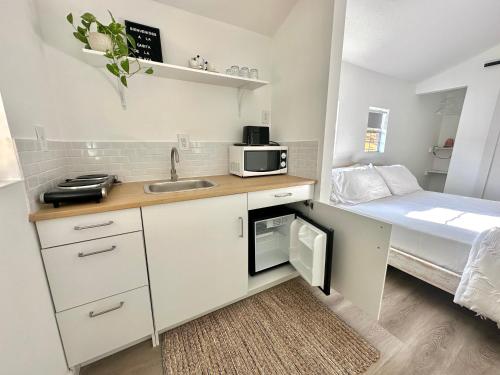 eine kleine Küche mit einem Waschbecken und einem Bett in der Unterkunft Beach guests house in Miami