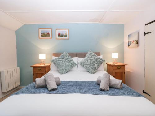 a bedroom with a bed with pillows and two lamps at Red Roof in Honiton