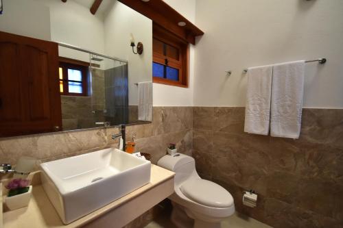a bathroom with a sink and a toilet and a mirror at Hotel Campanario Real in Villa de Leyva