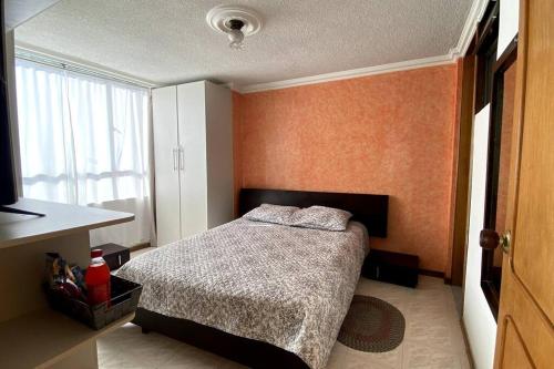 a small bedroom with a bed and a window at Apartamento acogedor, excelente ubicación in Pasto