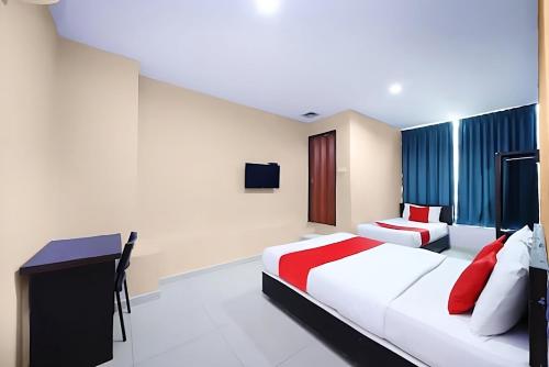 a hotel room with two beds and a desk at Hotel Inap in Batu Caves