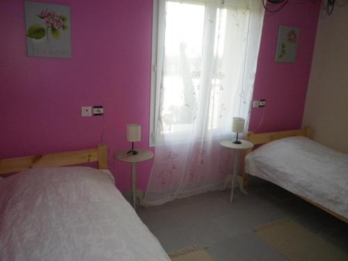 a bedroom with two beds and a window with pink walls at Gîte spacieux avec terrain clos, terrasse, 4 chambres, animaux acceptés, près de Belle-et-Houllefort - FR-1-376-104 in Belle-et-Houllefort