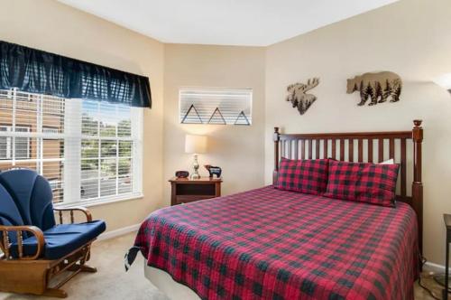 a bedroom with a bed and a chair and a window at Bandit's Riverfront Retreat - Mountain View- Condo-Fishing-Balcony-Fireplace-Great Location! in Pigeon Forge