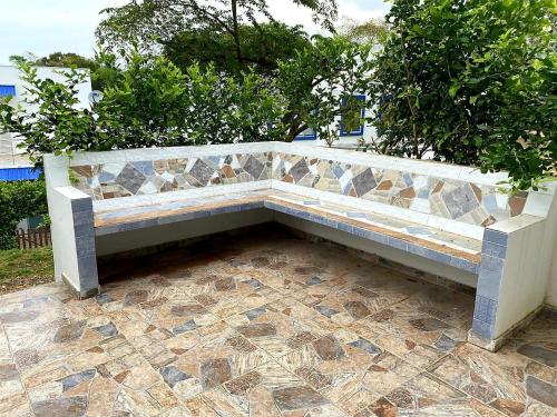 un banco de piedra en un patio de azulejos en Casa Vacacional en Carmen de Apicala, Colombia, en Carmen de Apicalá